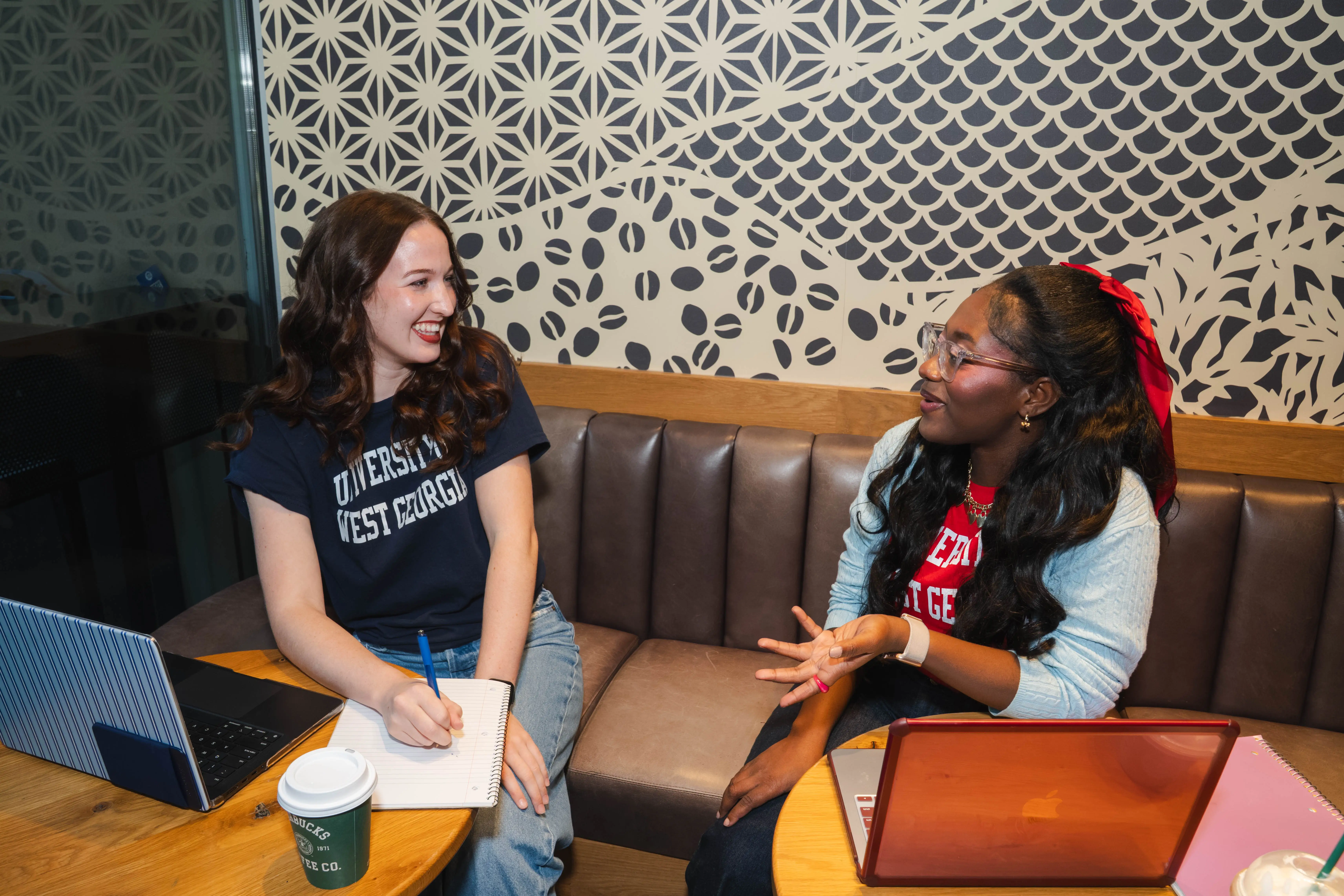 Two UWG students chatting and studying