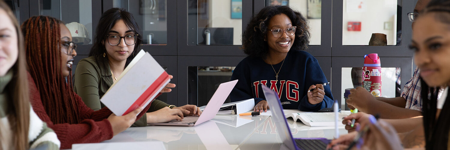 UWG Students sitting around a table interacting.