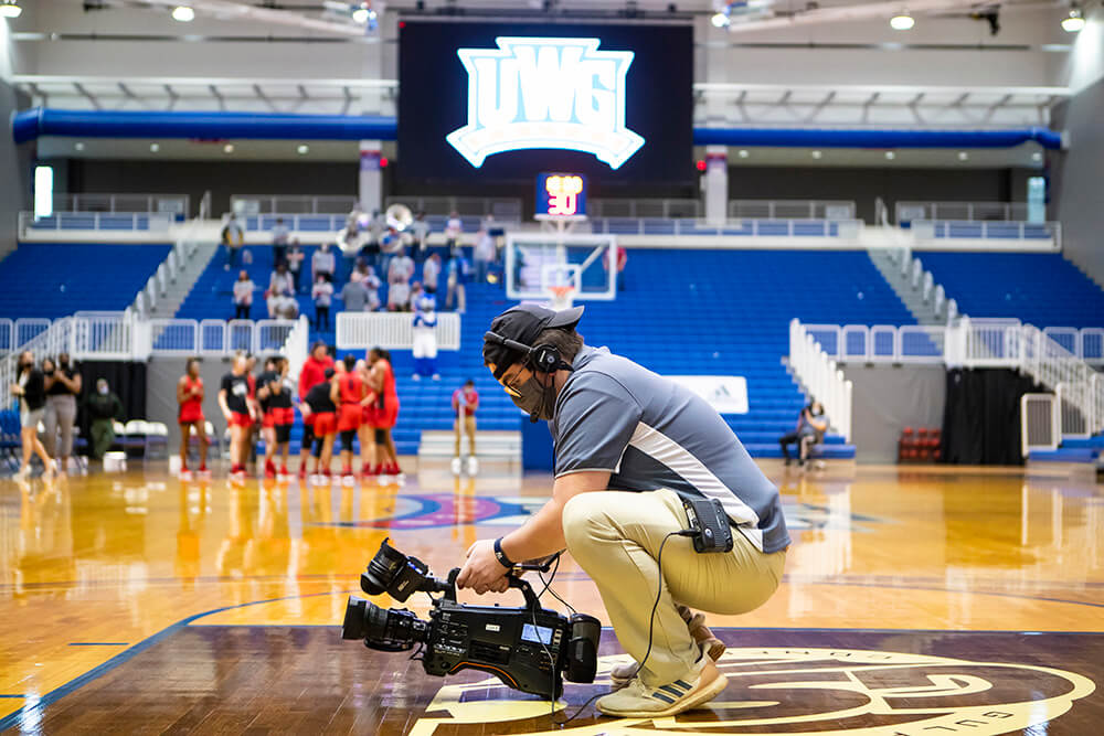 Cameraman looks at footage in the UWG Coliseum