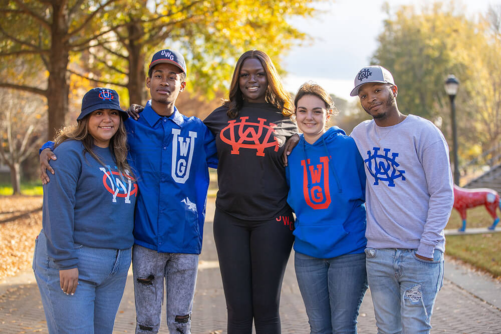 A group of five students outside on campus