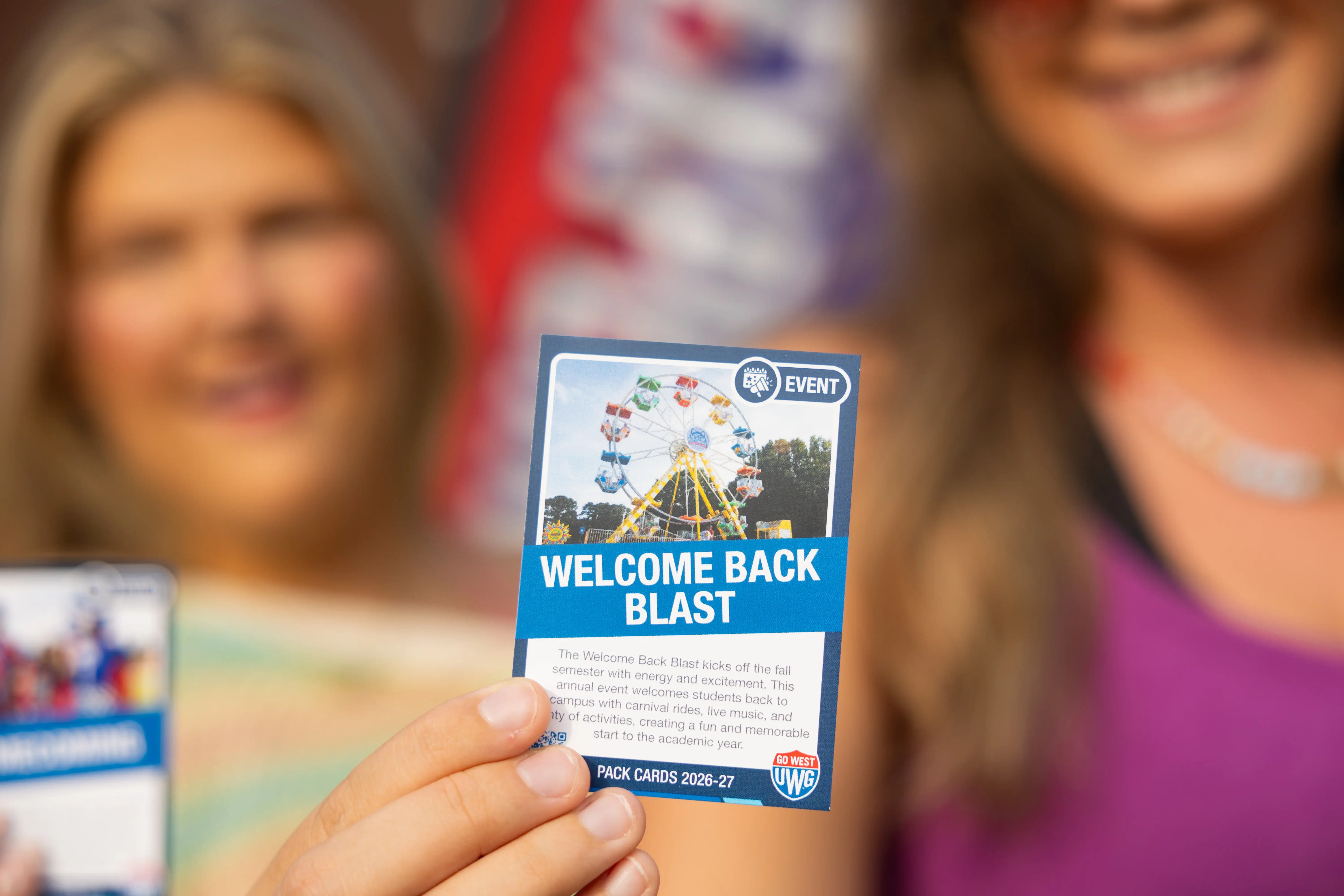 A UWG student holds up a Pack Card