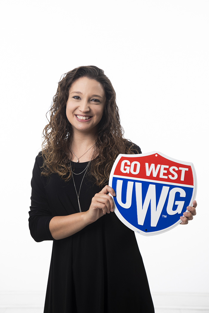 Amanda Wright holding a Go West UWG shield sign