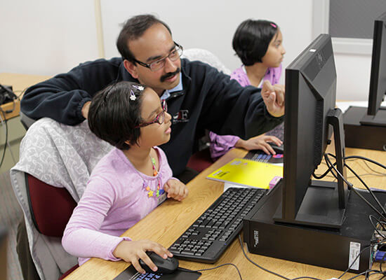 Man and child working on a laptop