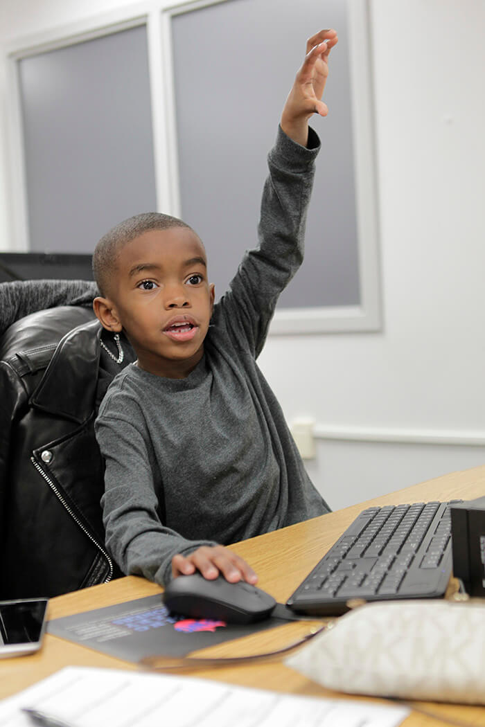 boy raising his hand in class