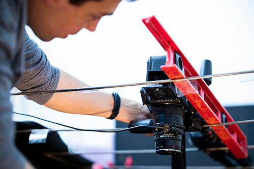 Mark Schoon hanging a camera