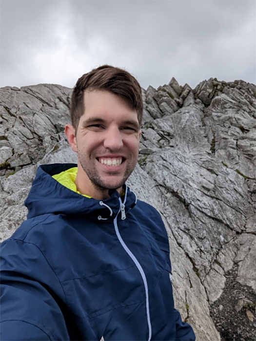 Sam Anderson standing in front of large rocks.