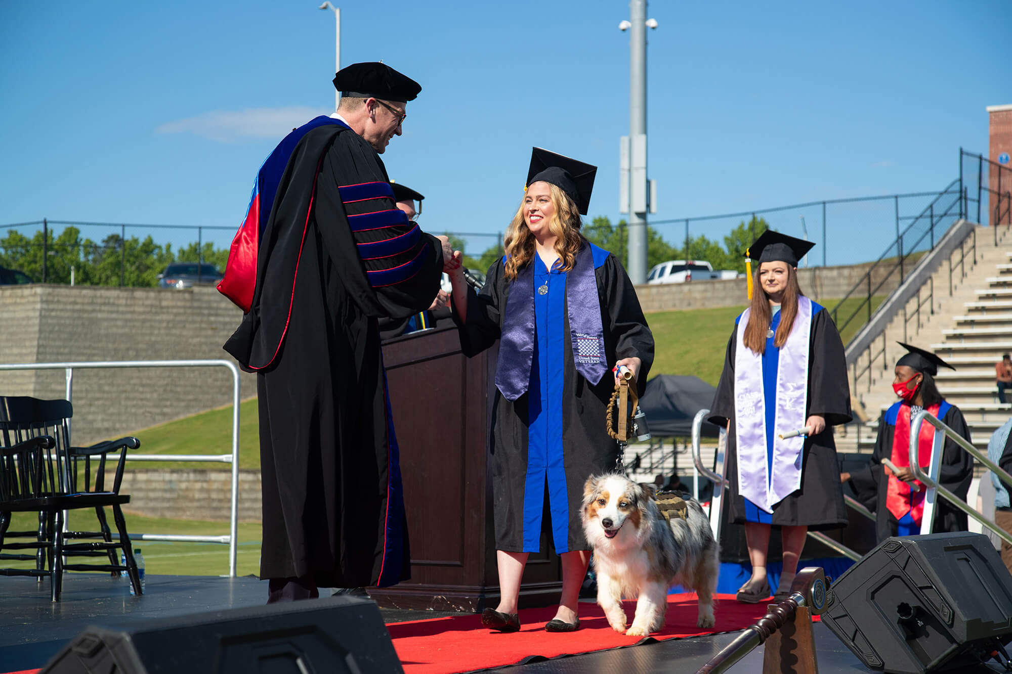 Furr and Misti walk across graduation stage to meet Dr. Brendan Kelly