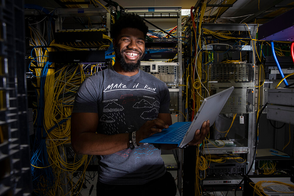 Student working on a laptop in a data room