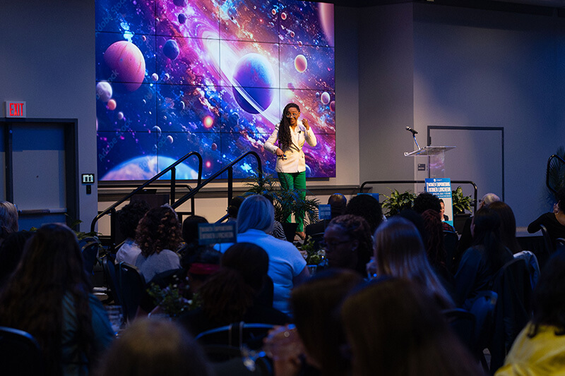 Tramaine EL-Amin speaking to a large audience at UWG's annual Women Empowering Women event