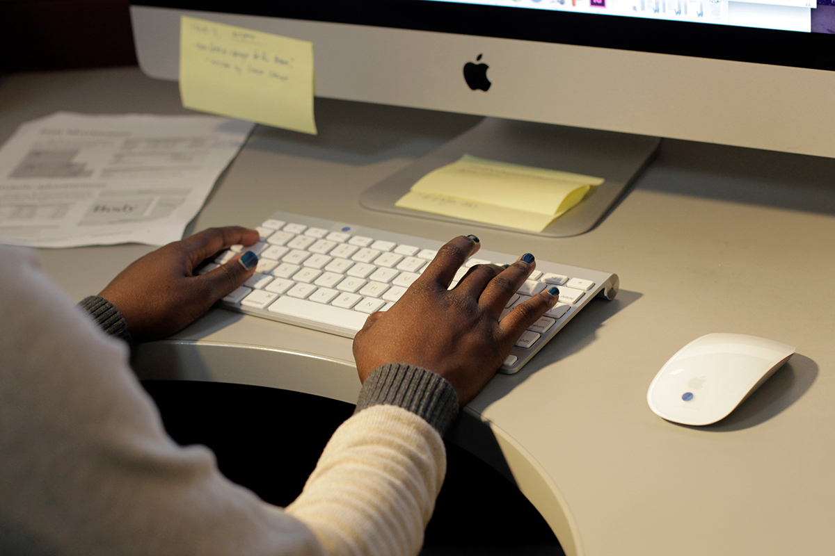 Student types on computer keyboard.