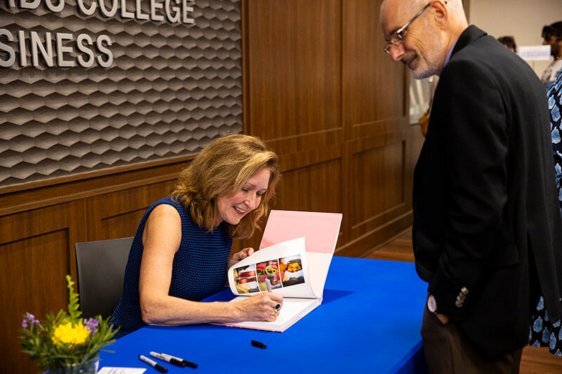 Nancy Richards Farese signs a copy of her book