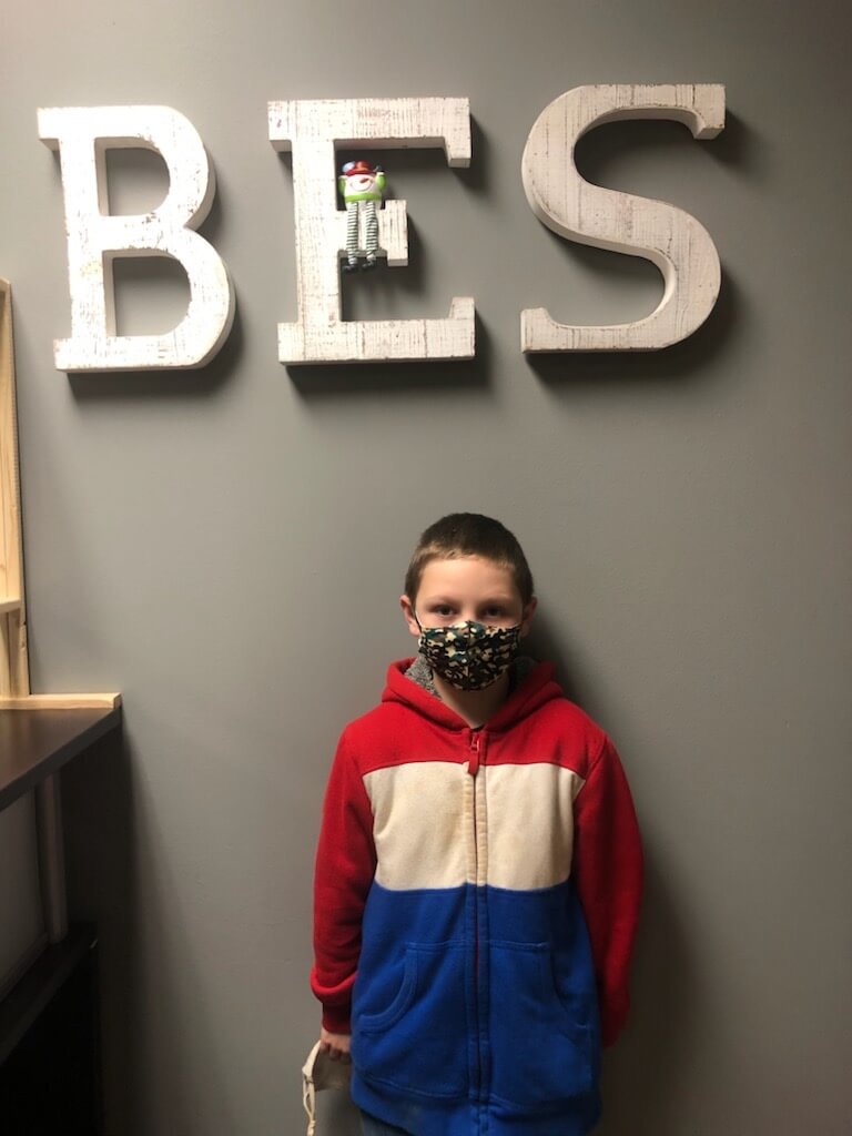 A young student wearing a mask
