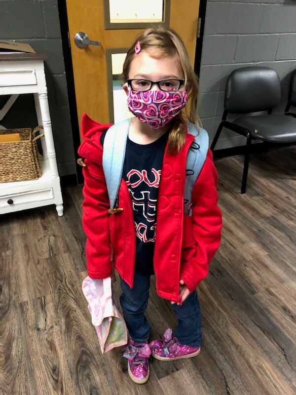 A young student wearing a mask