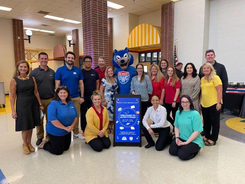Calhoun City Schools and University of West Georgia faculty and staff pose with Wolfie, UWG's mascot