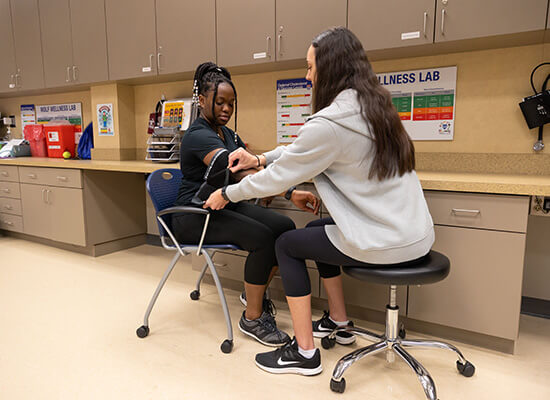 student checks another student's blood pressure