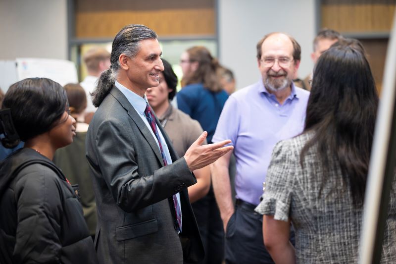 Dr. Ashwani Monga, UWG interim president, checks out students' research at Scholars' Day