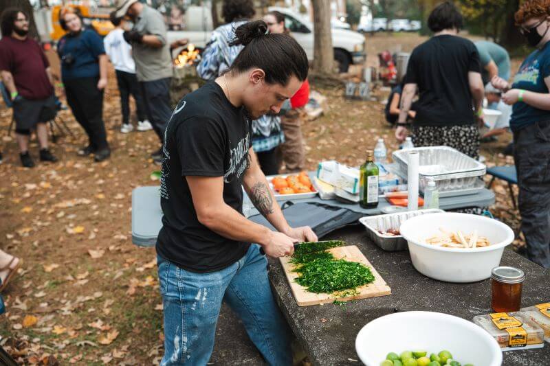 UWG student preparing food outdoors at Paleofeast