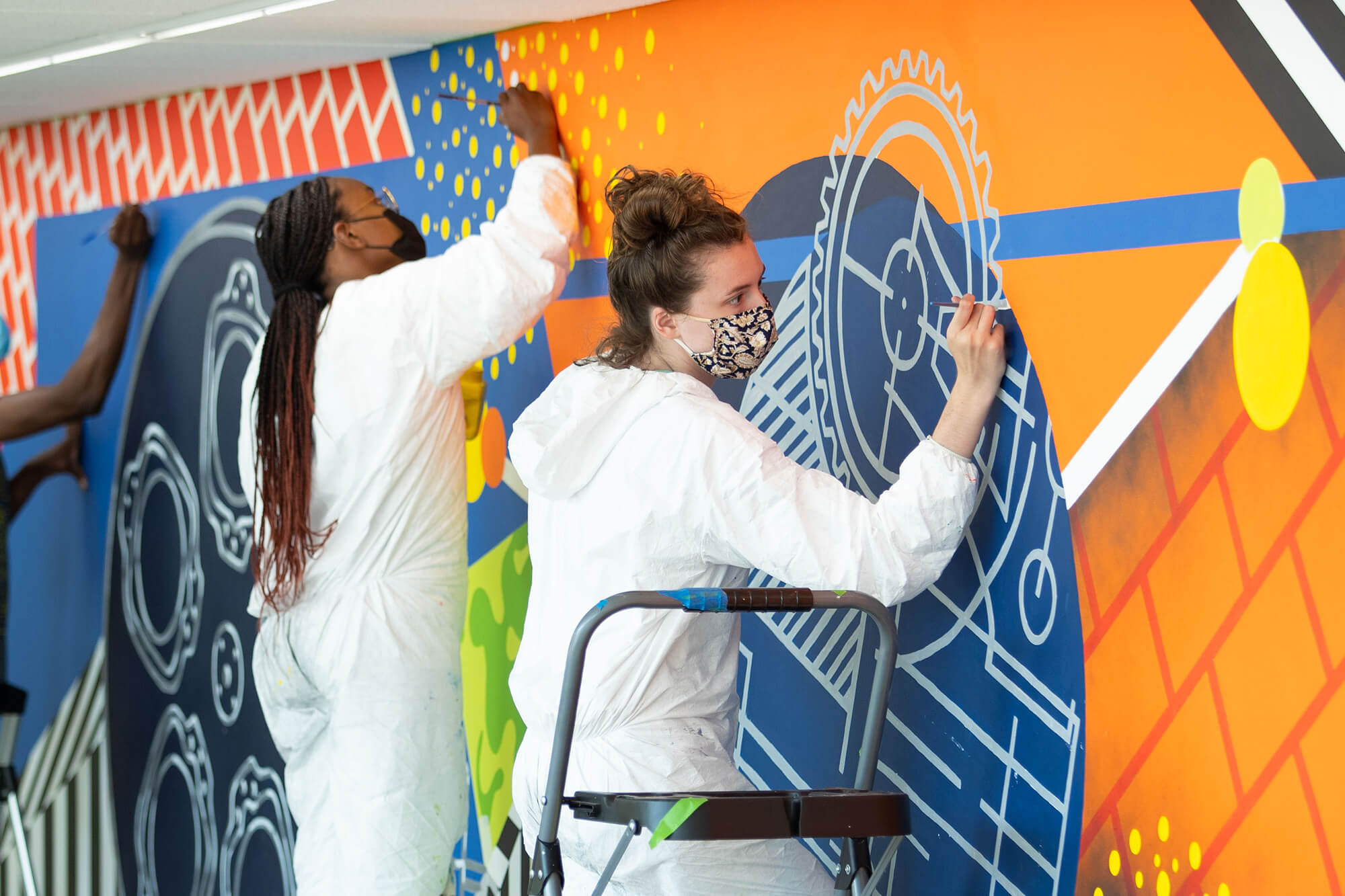 Piper Heaton and Ariana Culver work on a mural.