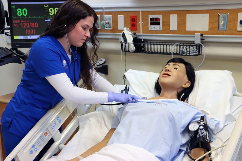 UWG nursing student working with manikins