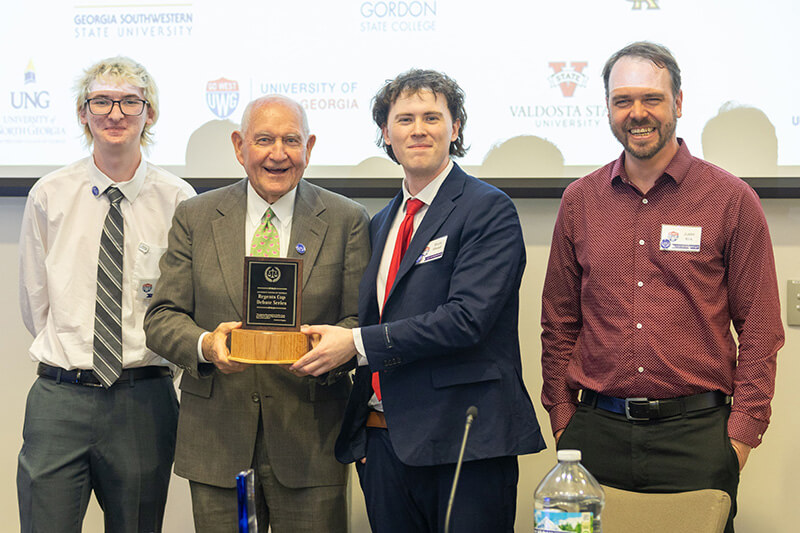L to R: James Kennon, UWG Debate; Dr. Sonny Perdue, USG chancellor; Bruce Bissell, UWG Debate; Justin Kirk, UWG Debate director