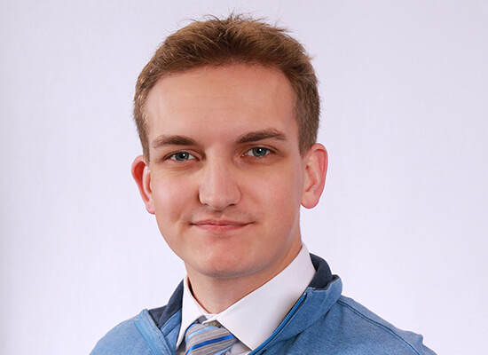 Zachary Tafelski poses for a portrait in a blue sweater 