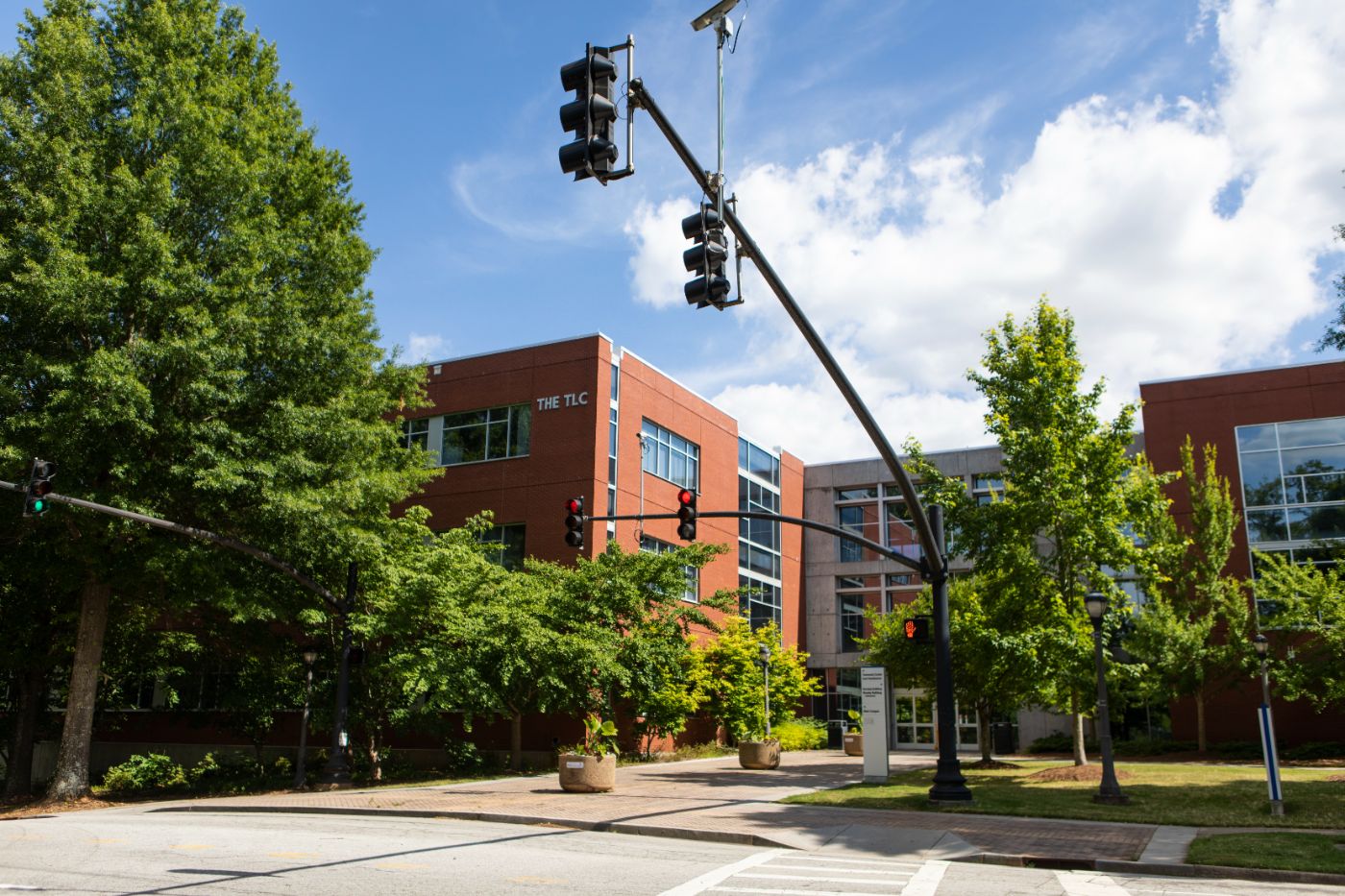 Exterior of the Technology Enhanced Learning Center highlighting large glass windows and small trees as seen from in front of The Bookstore, across the street.