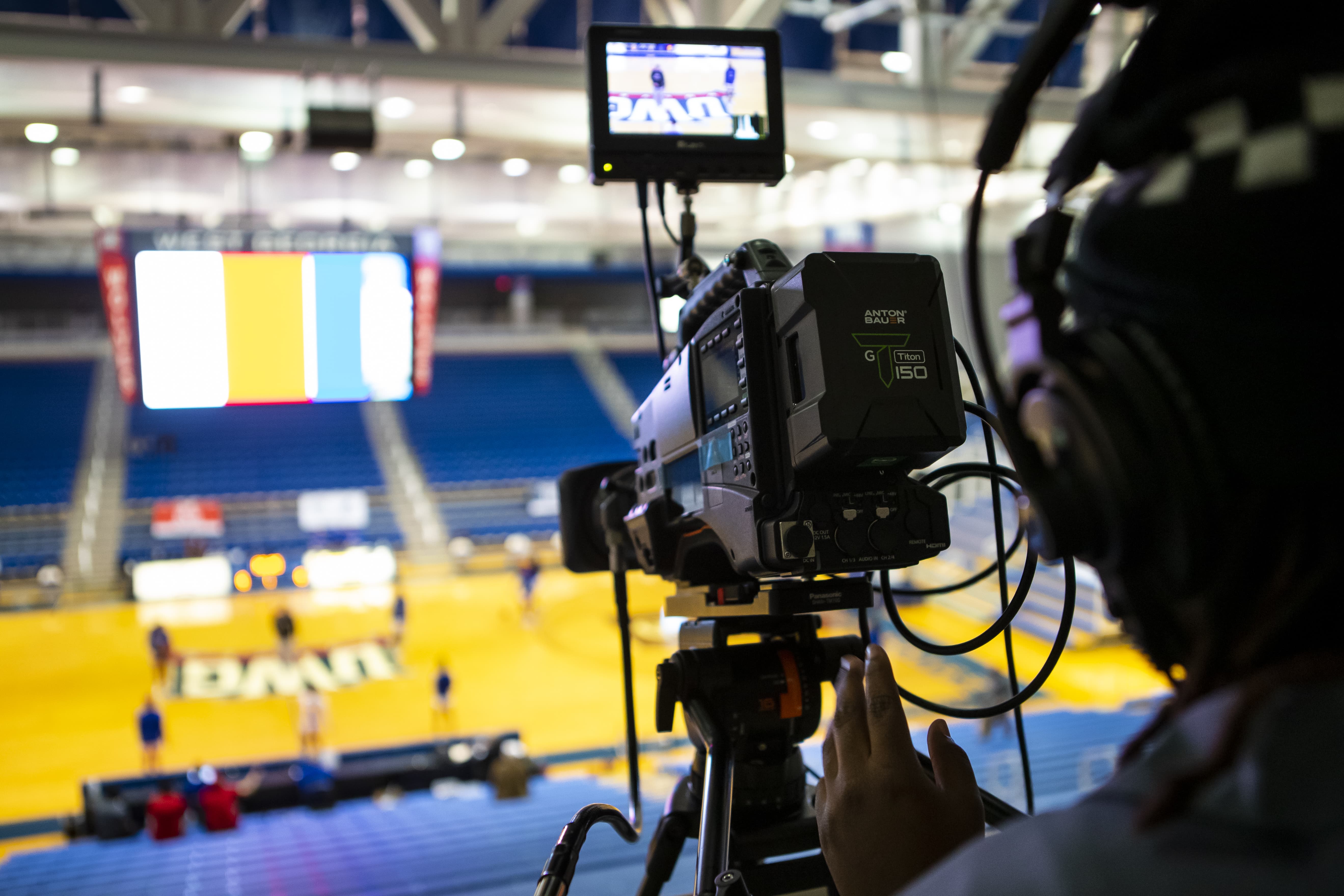 Student filming womens basketball.