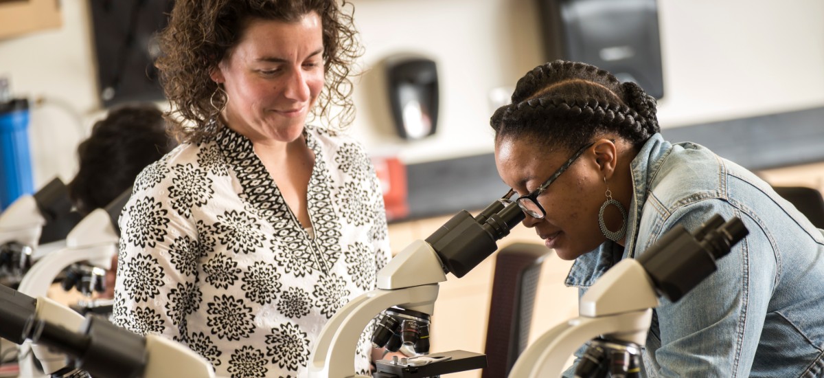 student, teacher and microscope