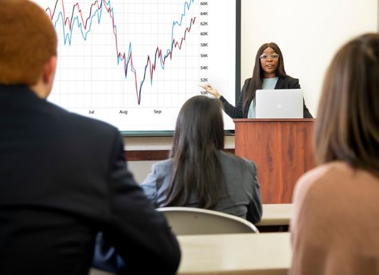 Student making a presentation in front of a graph