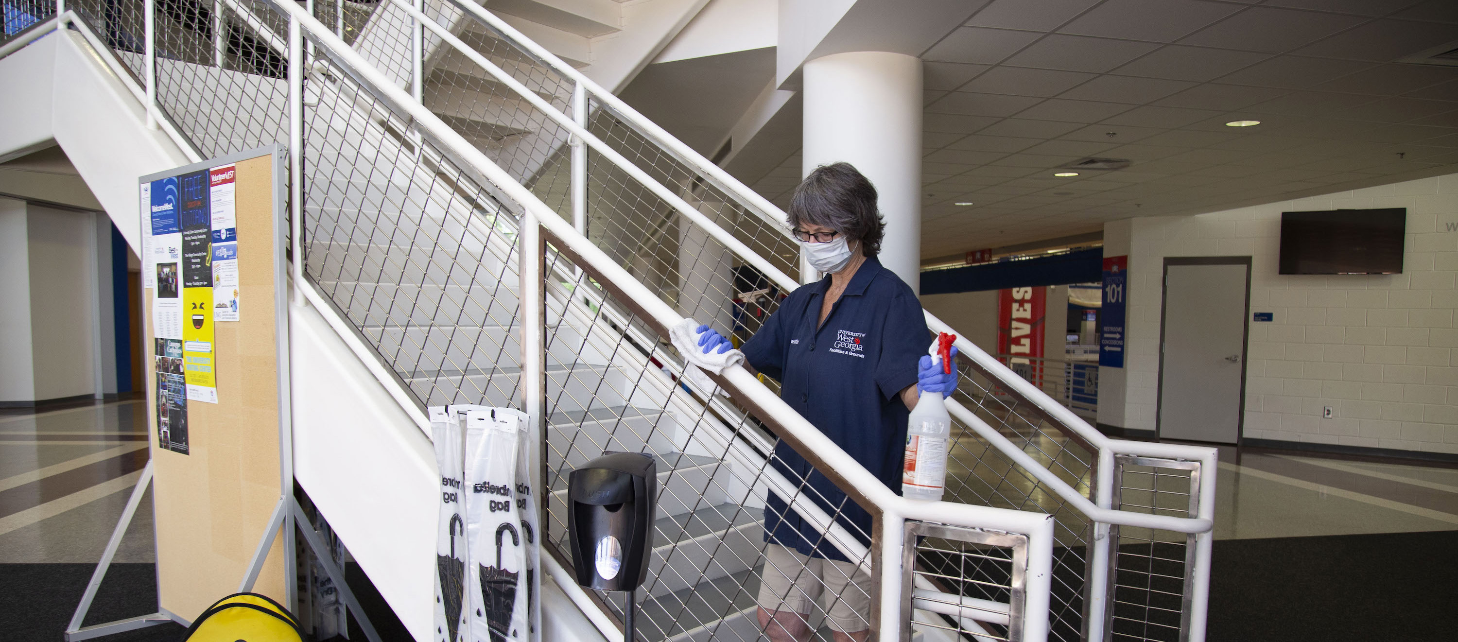 custodial staff member disinfecting a surface