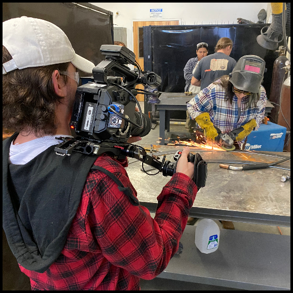 production student filming art student welding