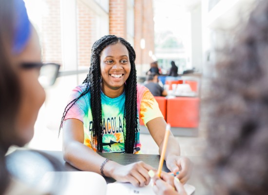 female student smiling while sitting in the campus center