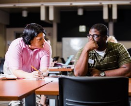 Students speaking at a table in Ingram Library.