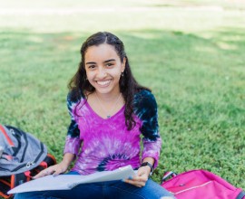 Student reading a book outside.