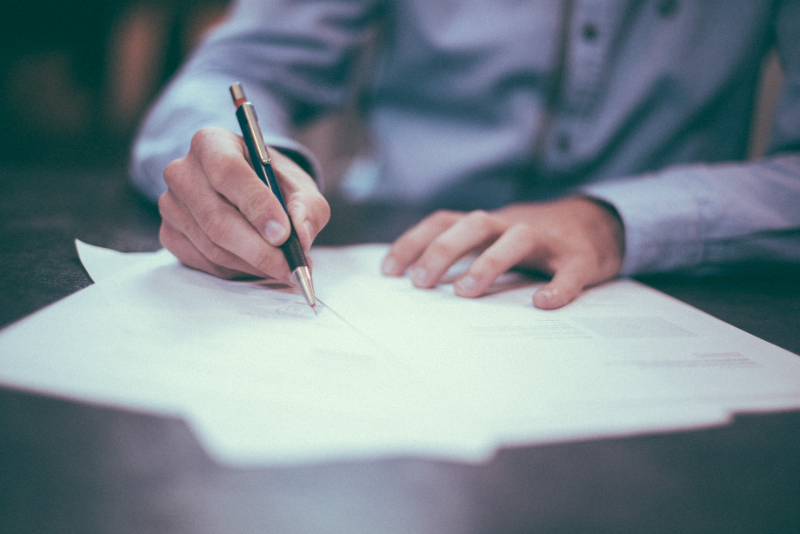 student signing papers