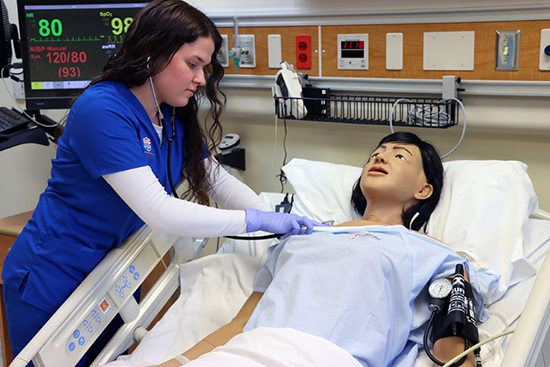 Nursing student looking at and setting up and IV bag.