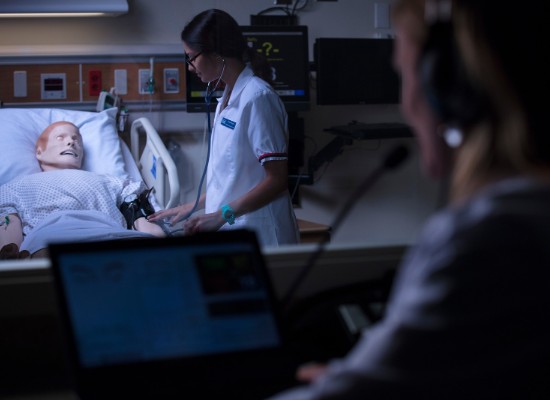 nursing students in an experiental classroom working with an artificial patient