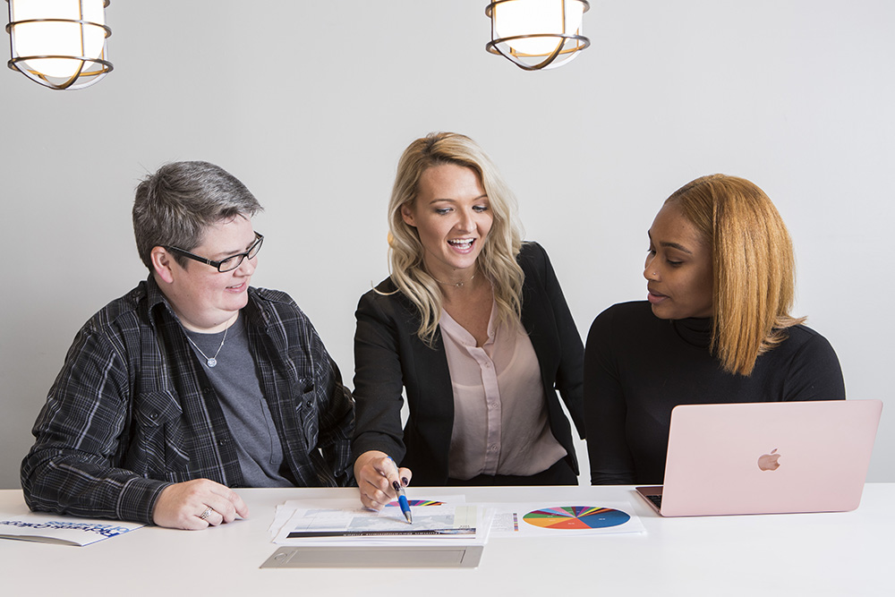 Three UWG Business students collaborate on an assignment together. 