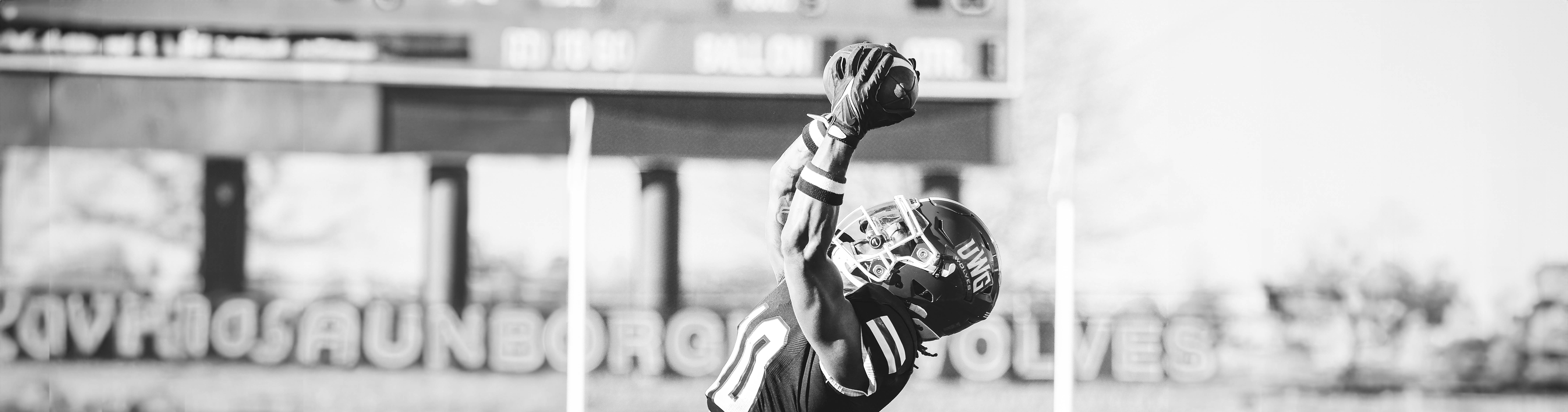 UWG Football Player jumping into the air to catch the football.