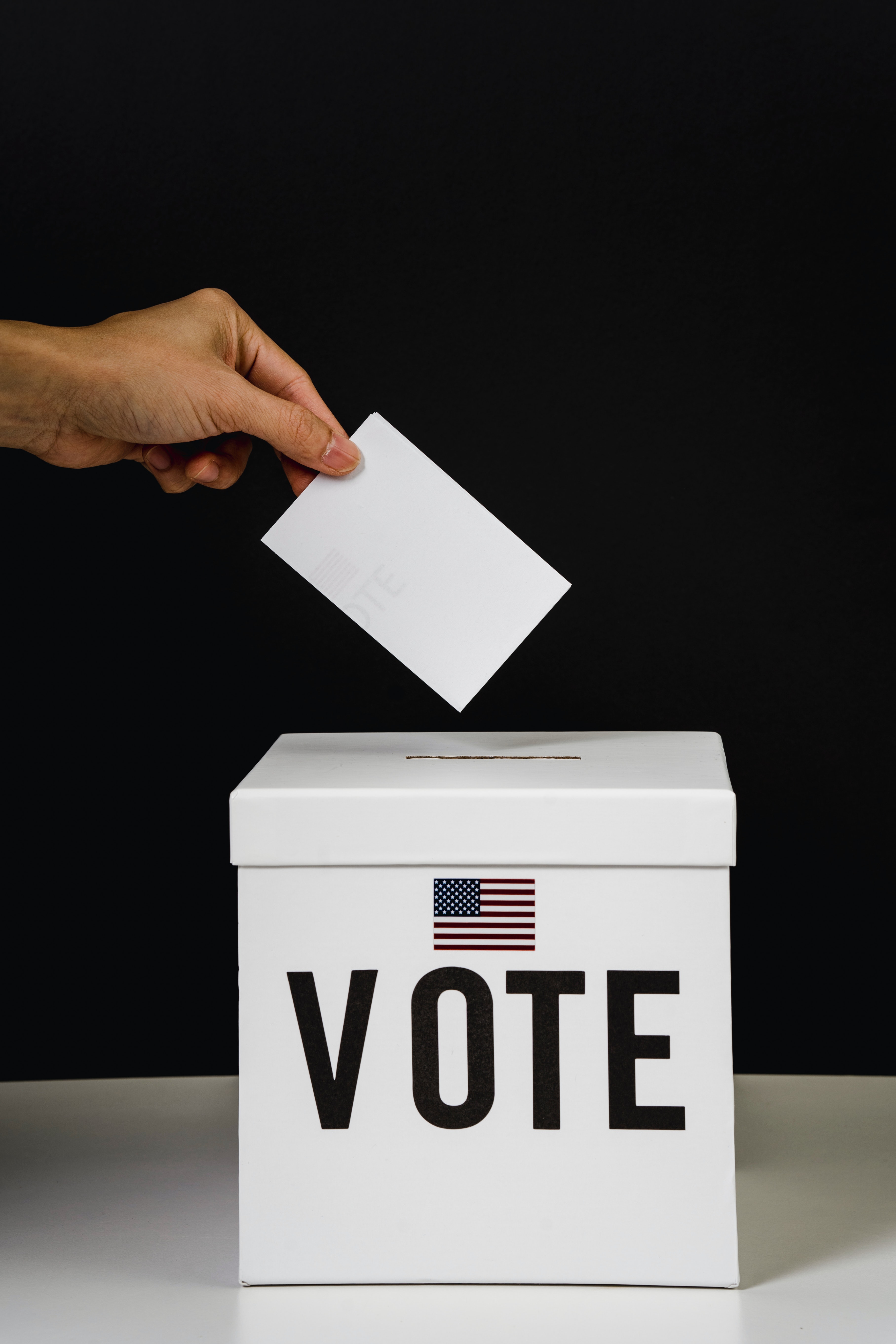 A person putting paper in a voting box