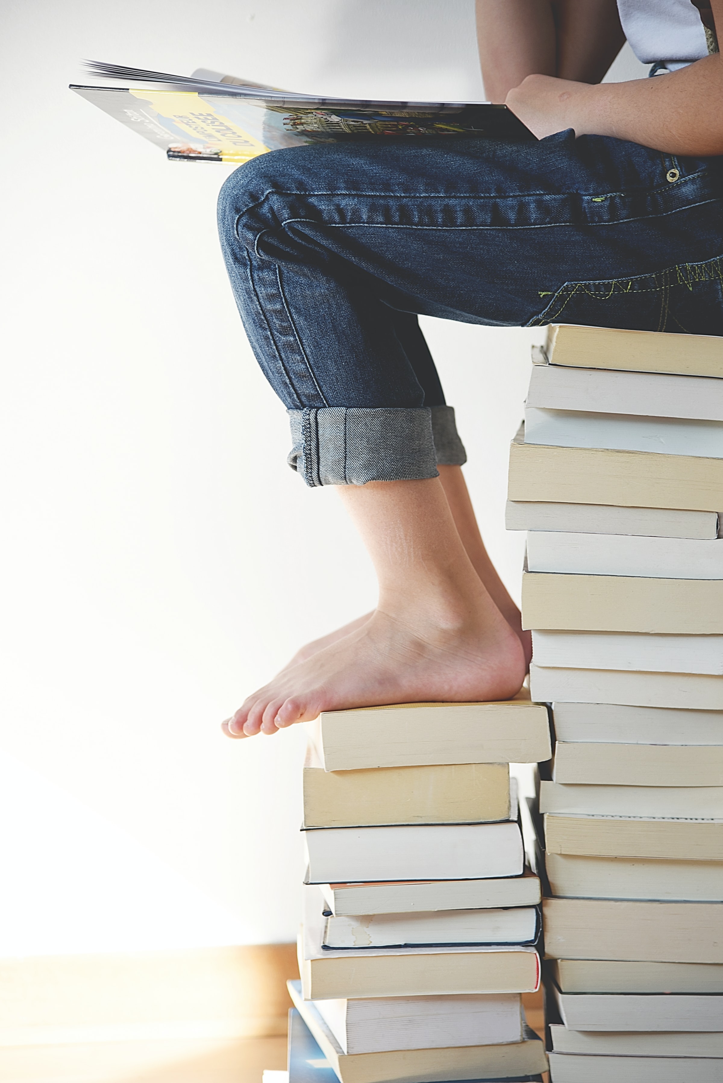 Person sitting on a pile of books