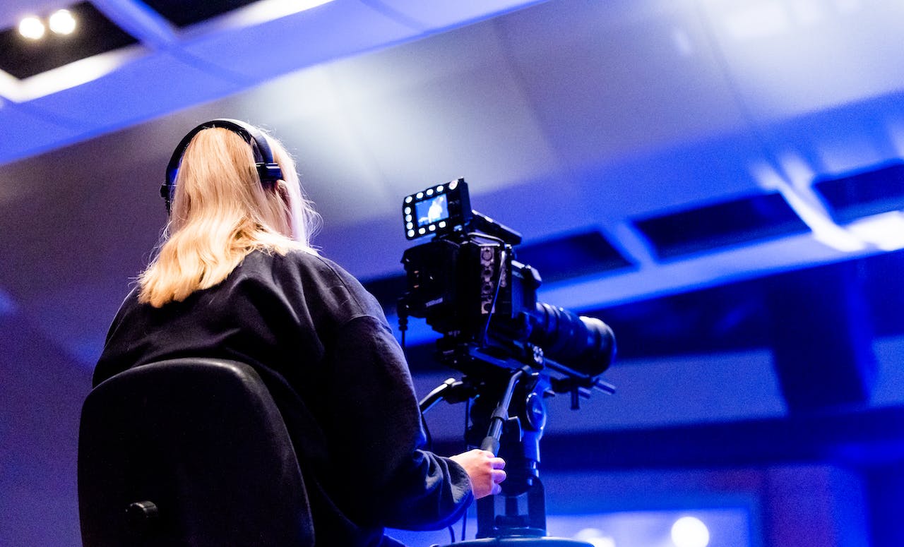 A Videographer Filming using a Black Video Camera