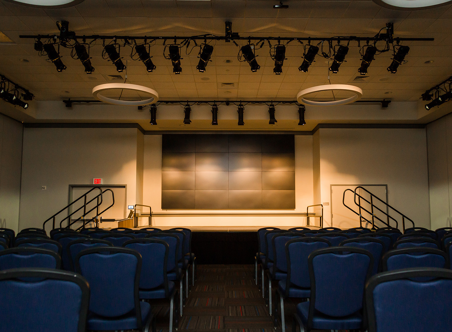 Ballroom 108.2 with full lecture setup and dimmed lights