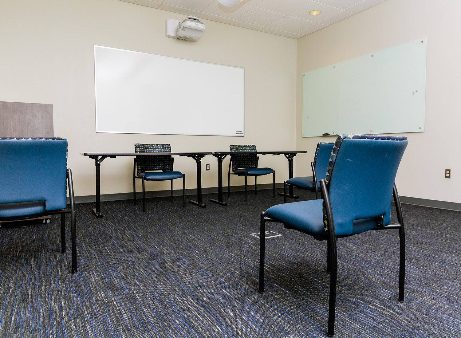 Meeting Room 104 view facing right with chairs, podium, and a whiteboard