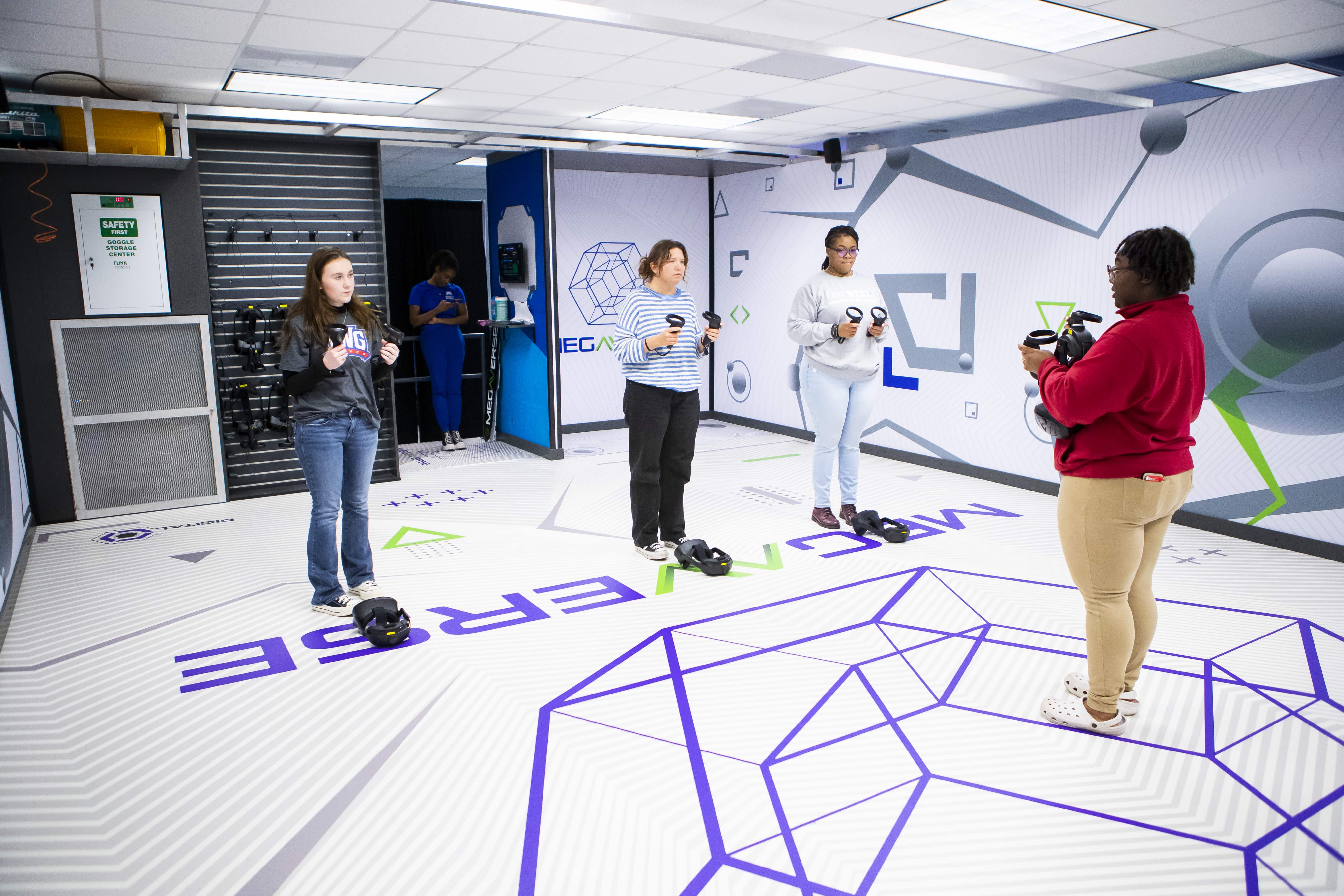 Three students being instructed on how to use virtual reality equipment.