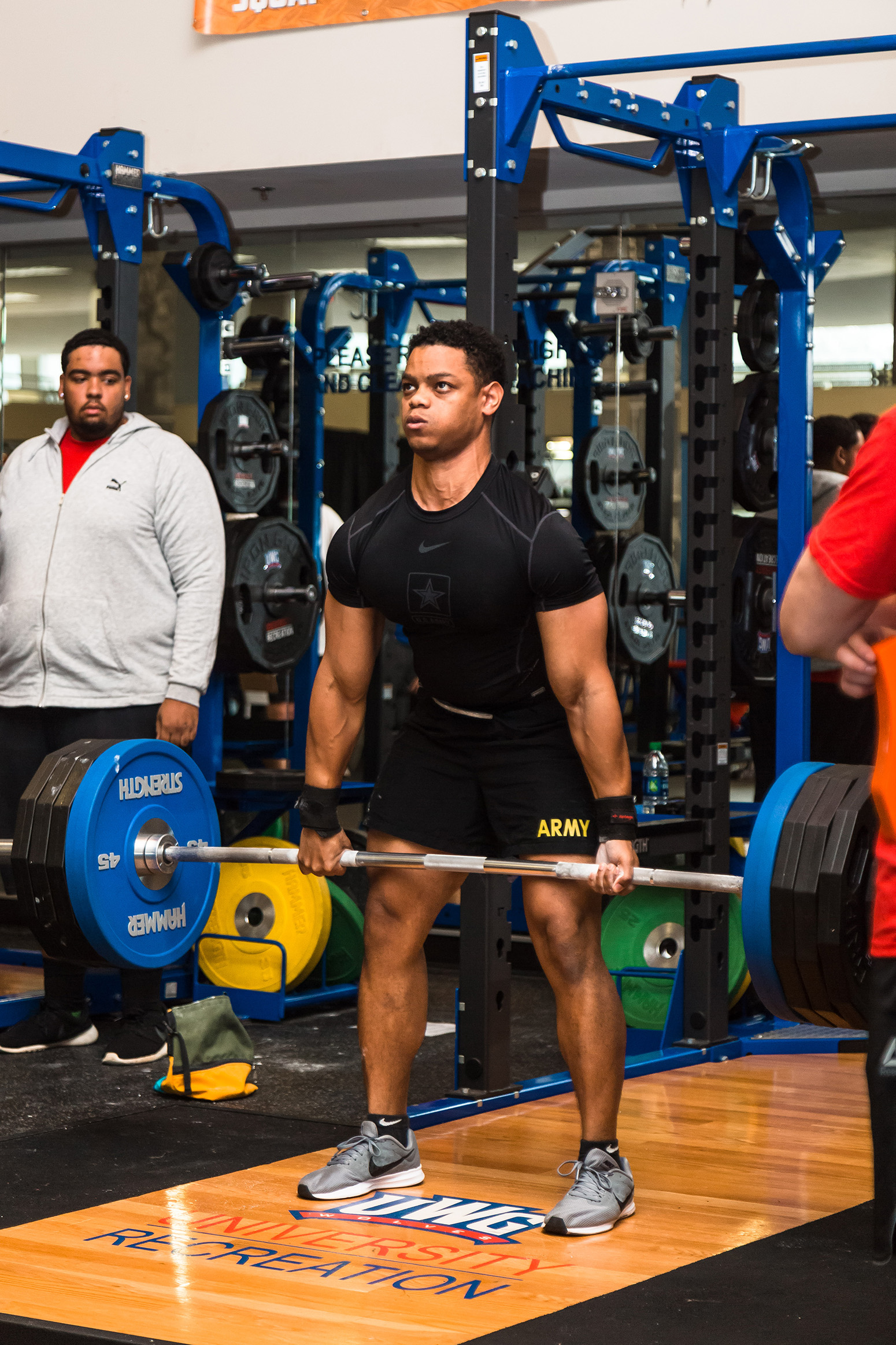 Student with army shorts doing a deadlift at the Campus Center during a powerlifting competition