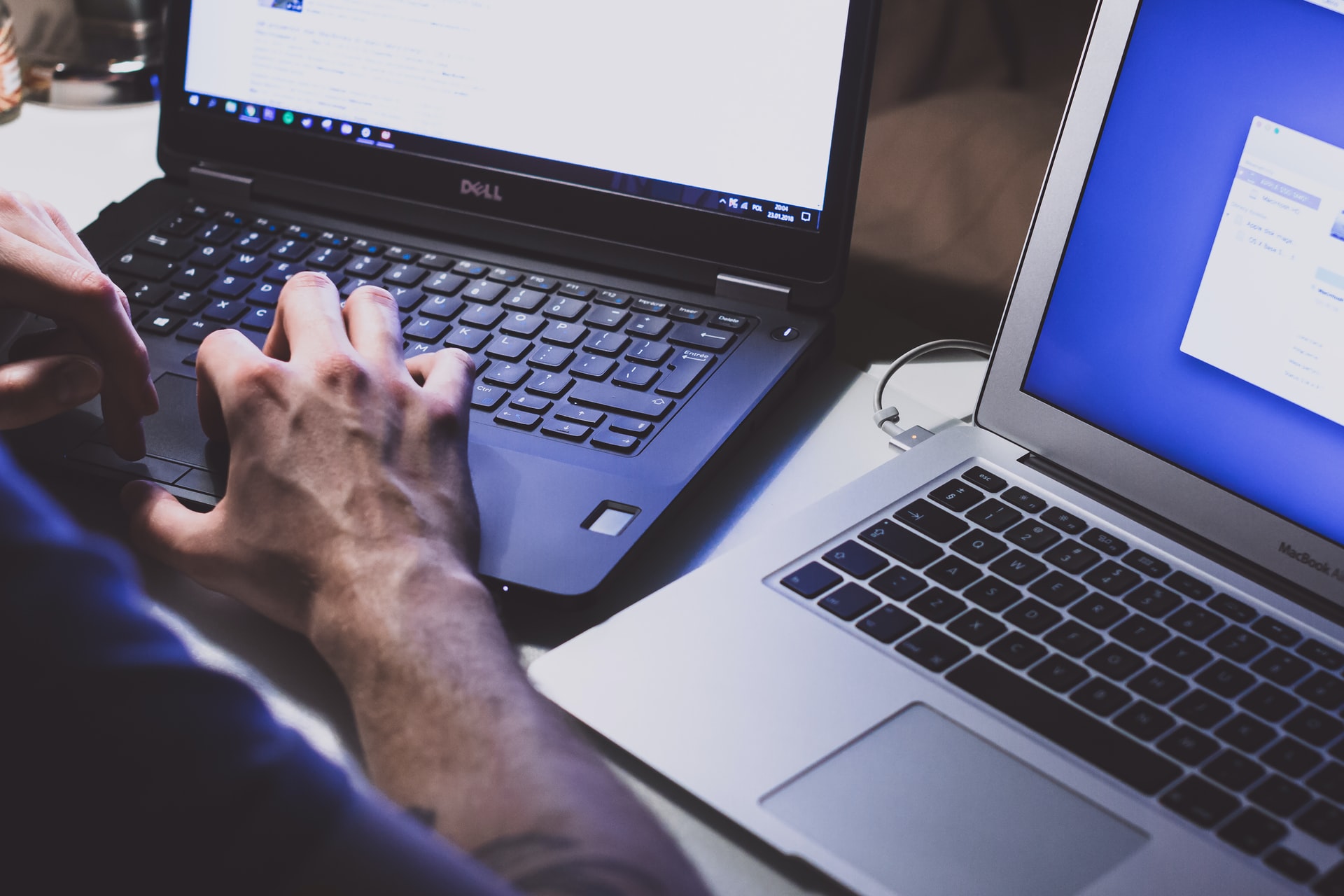 Person typing at two computers