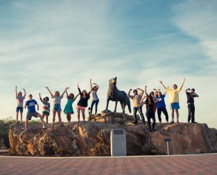 People cheering with wolf statue