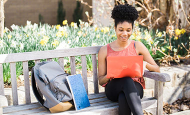 A student studying outside on a laptop