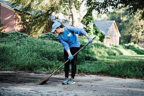 A young woman cleaning the road